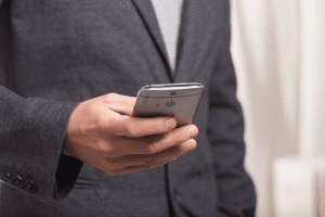 man in suite checking his phone