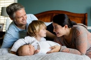 family of four laying on the bed